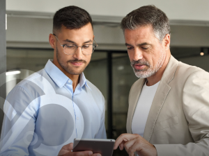 Two professionals reviewing cloud security data on a tablet, representing collaboration in a Continuous Cloud Security Model.